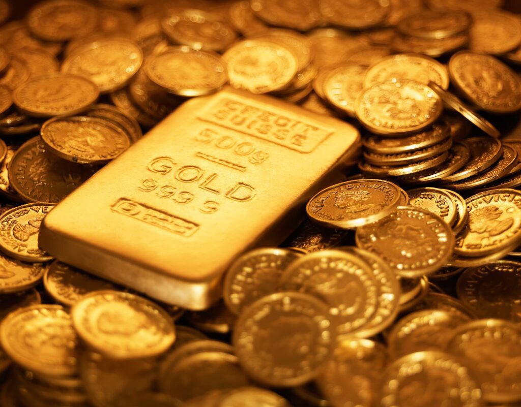 gold bar on top of scattered gold coins